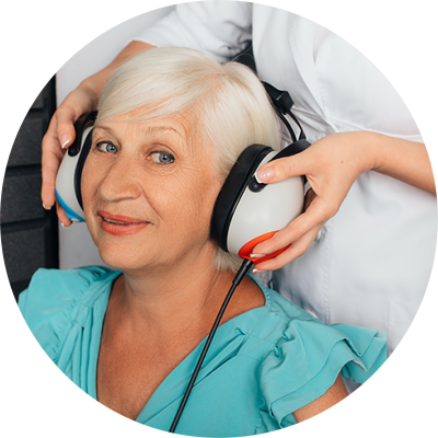 Woman wearing headphones that are being held by a doctor